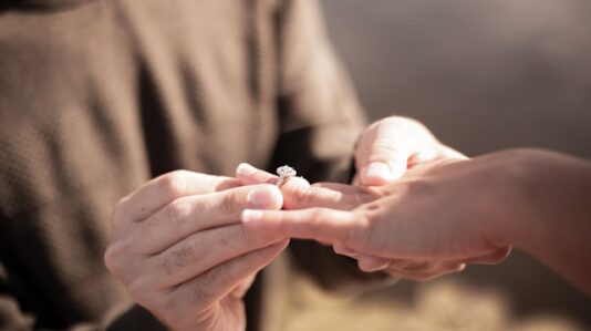 a person putting a ring in a hand