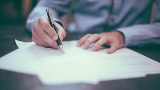 man signing a paper