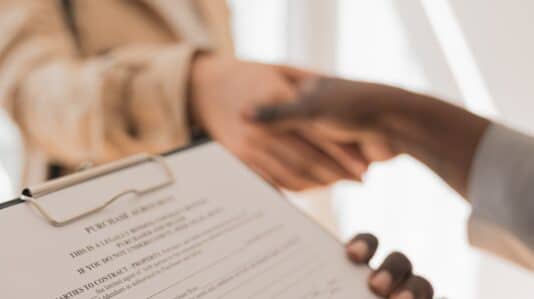 two people shaking hands after agreeing in a contract