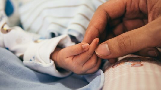 baby hand holding parent's hand