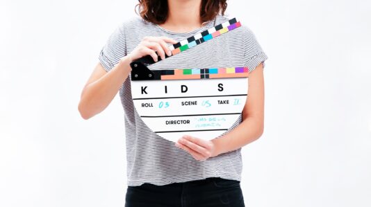 a woman holding a clapping board