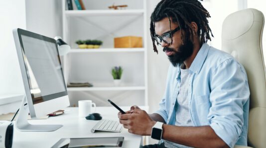 man in light blue t-sirt using a mobile