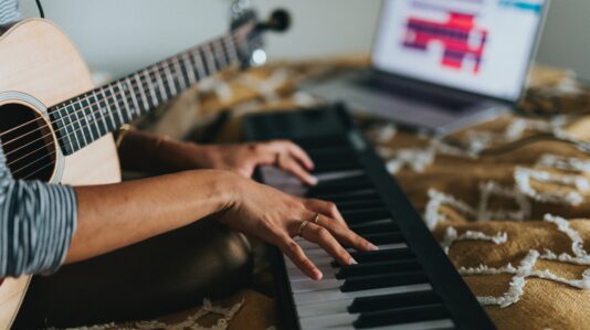 person holding a guitar and playing the organ