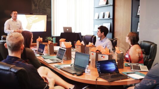 man standing in front of people sitting with their laptop