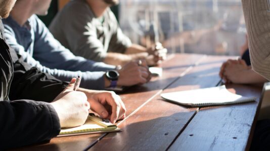 people sitting, making notes