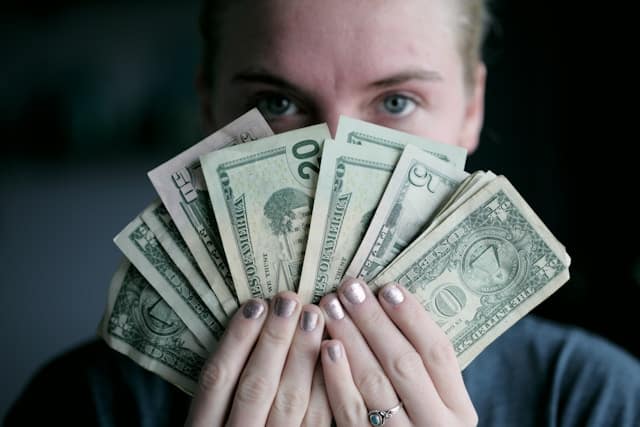 a woman holding money bills