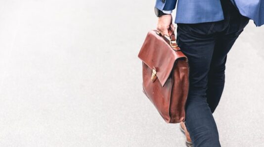 a man holding a brown business bag