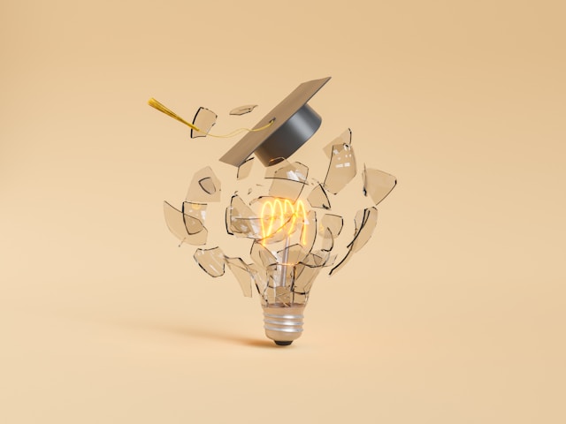 a broken light bulb with a graduation cap on top
