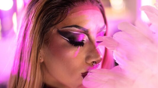 a woman in full make up, close eyes