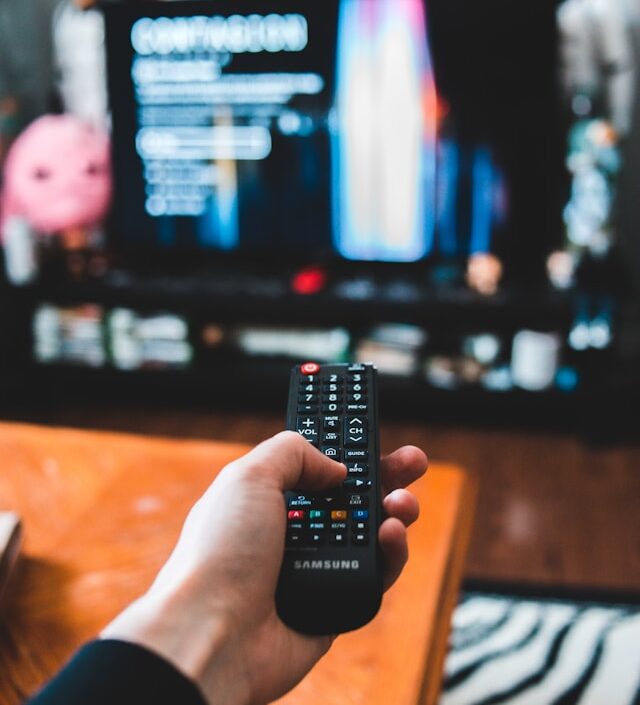 a hand holding a remote control