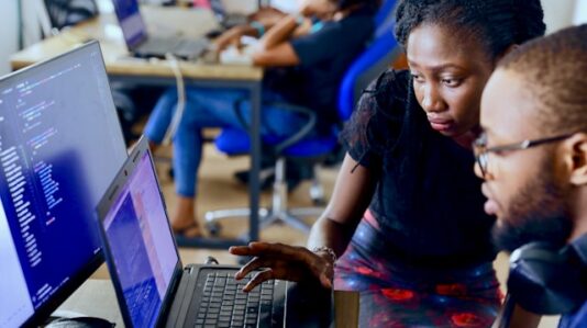a man and woman looking at the laptop screen