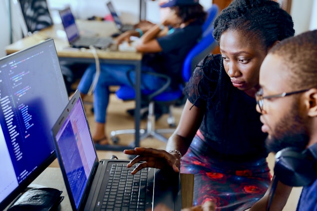 a man and woman looking at the laptop screen
