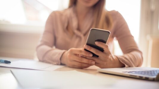 a woman holding, using a mobile