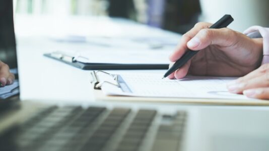 a keyboard and writing pad on a table