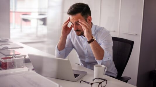 a man holding his temples, having headache