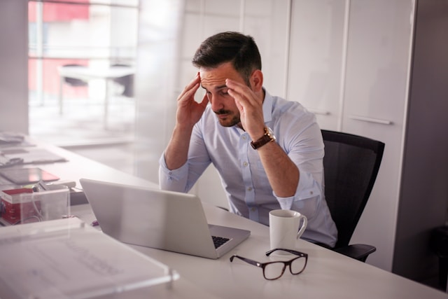 a man holding his temples, having headache