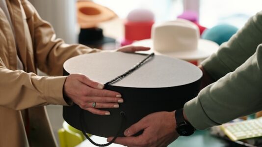 round hat box handed to a person