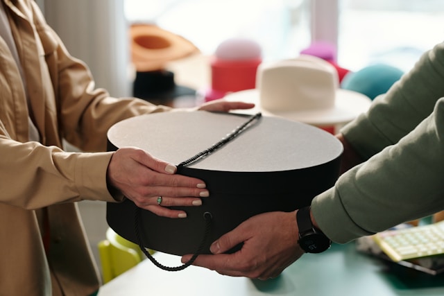 round hat box handed to a person