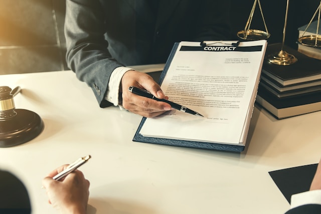 a document in a clipboard and a ballpen pointing on signature line