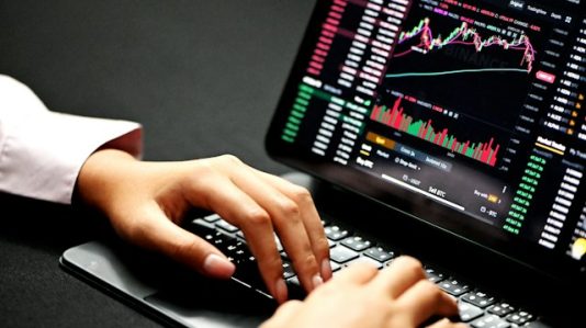 person using black laptop with graphs on screen